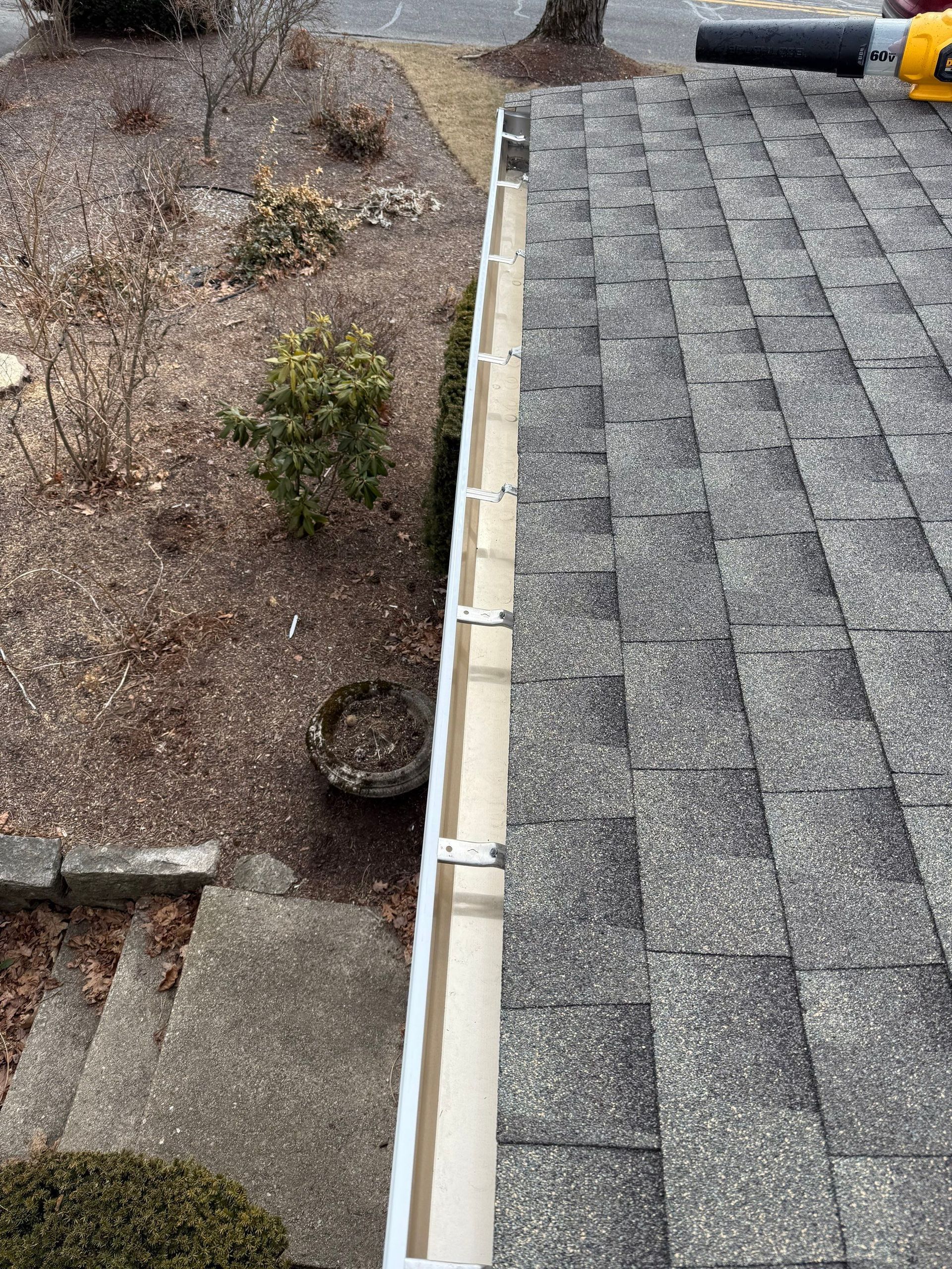 Roof with new shingles and clean gutters.