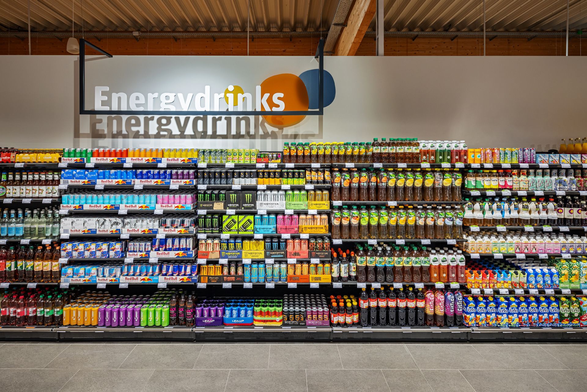 Retail Innenausbau gewerblicher Umbau tegut Supermarkt Witzenhasen - Helle Verkaufsfläche in einem Supermarkt mit Produktregalen, breiten Gängen und Decken mit Holzelementen – Referenzprojekt Ladenbau und Innenausbau Generalunternehmer