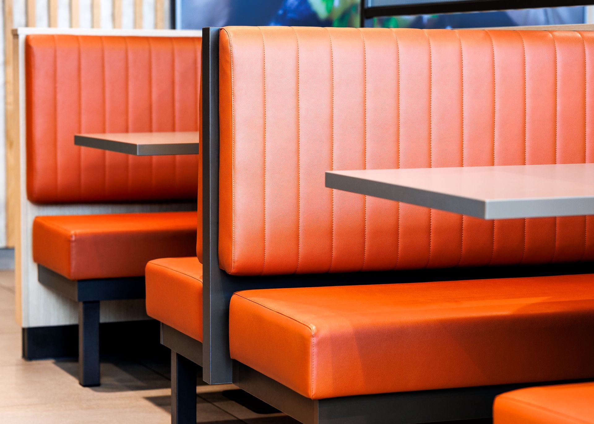 Restaurantumbau Burger King Vösendorf - Moderner Sitzbereich im Gastronomie-Interieur mit orangefarbenen Polsterbänken  – Referenzprojekt Ladenbau und Innenausbau Generalunternehmer
