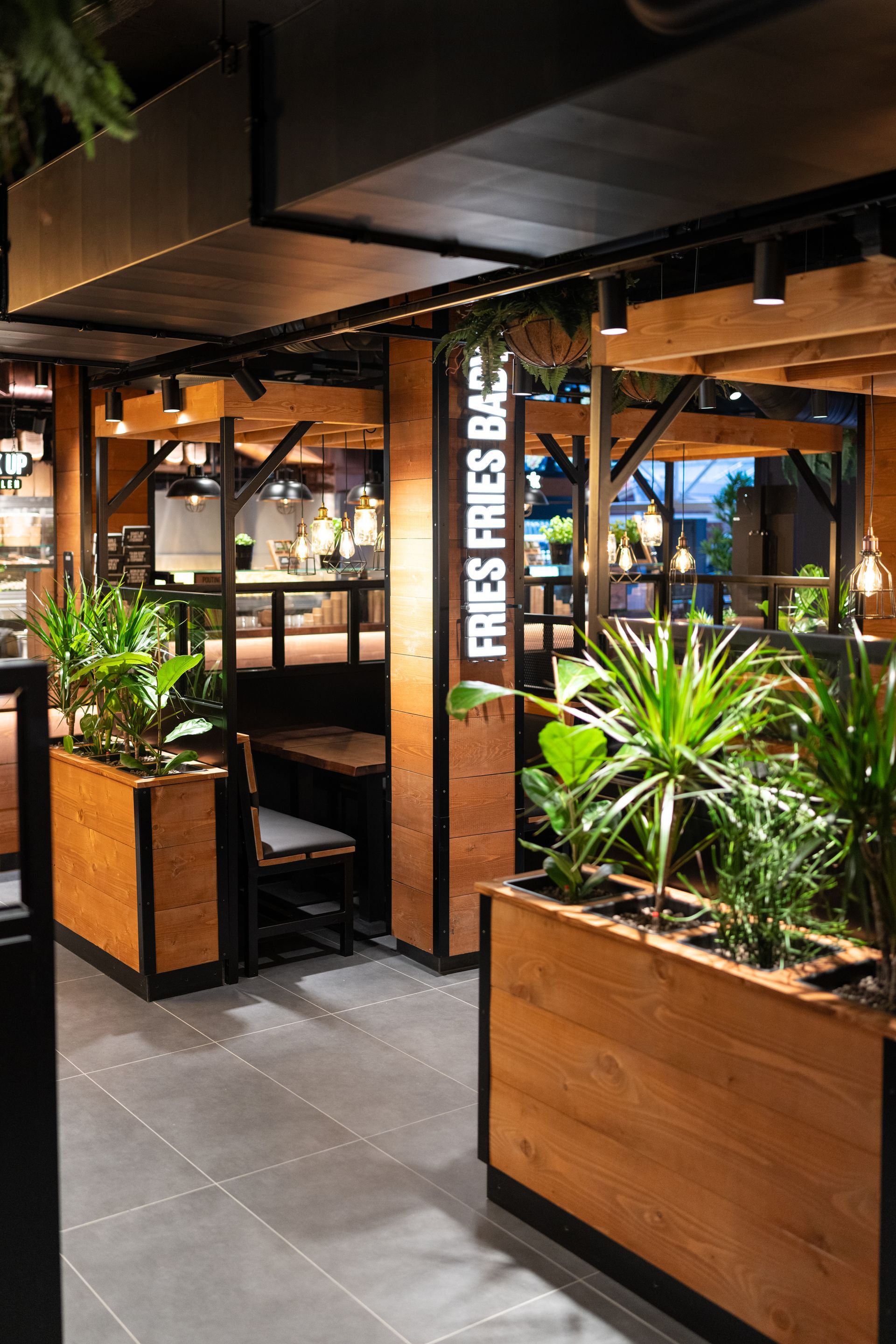 Innenausbau Frittenwerk Flensburg - Restaurantumbau - Restaurant Innenraum mit maßgeschneiderten Schreinermöbeln und Sitzgelegenheiten im Industriestil - Referenzprojekt Generalunternehmer Innenausbau