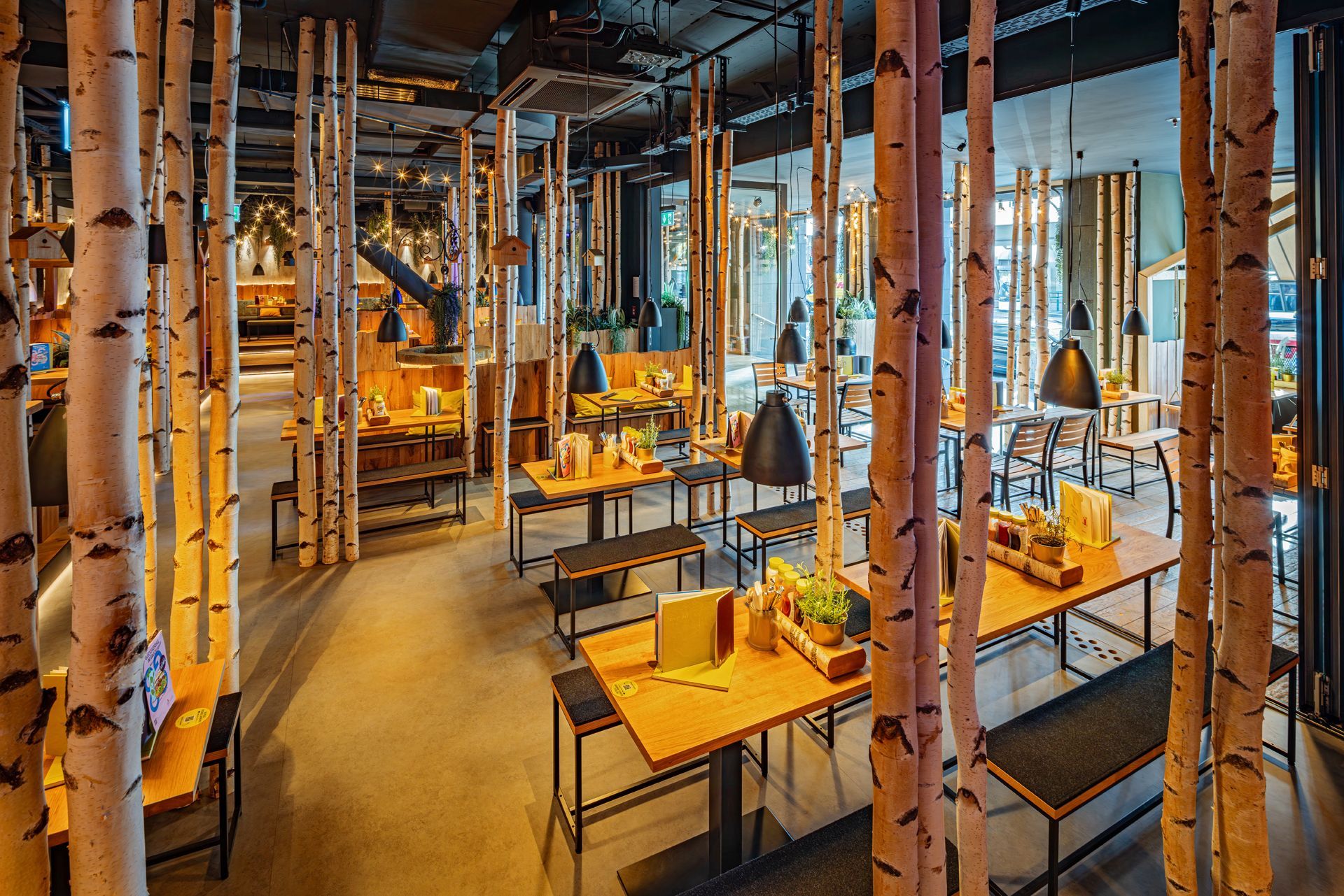 Hans im Glück Berlin - Moderner Gastronomie-Essbereich mit maßgeschneiderter Inneneinrichtung aus Holz, dekorative Wandelemente – Referenzprojekt Restaurantumbau Generalunternehmer Innenausbau