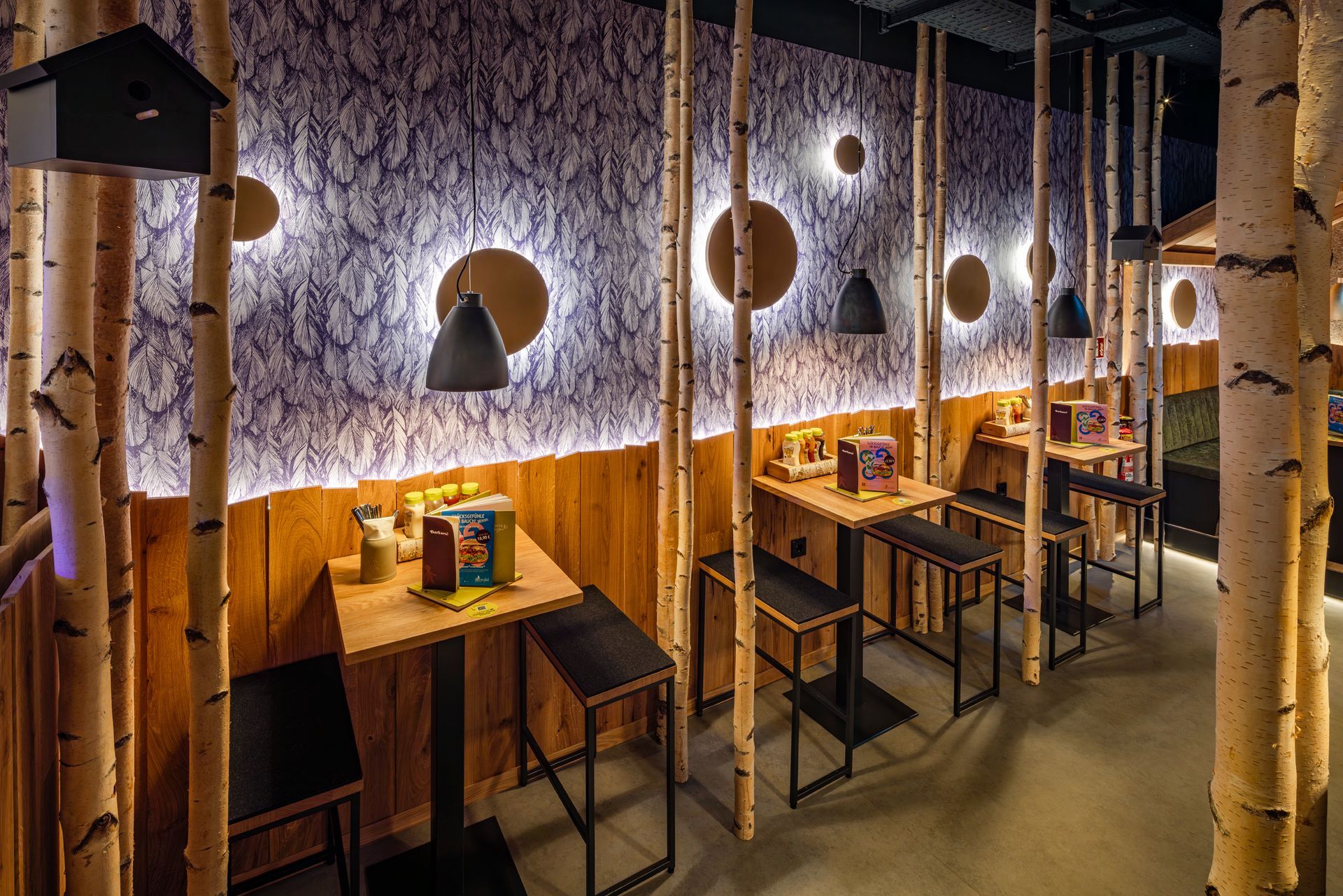 Hans im Glück Berlin - Moderne Gastronomie-Sitzecke mit stilvoller Inneneinrichtung, dekorative Leuchtelemente – Referenzprojekt Restaurantumbau Generalunternehmer Innenausbau