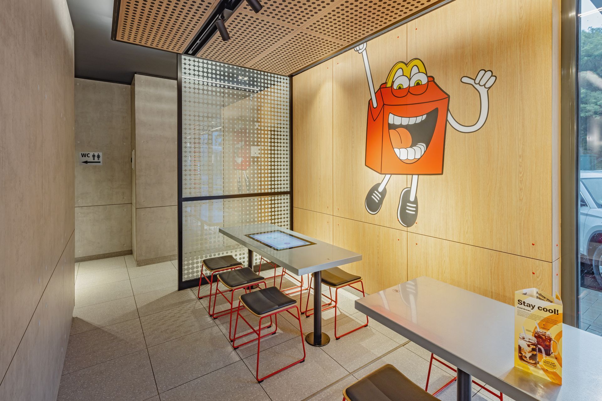 McDonald's Innenausbau Ray Bochum - Restaurant Innenraum mit maßgeschneiderten Schreinermöbeln und Sitzecke für Kinder und Jugendliche mit digitalem Spieletisch von McDonald's - Referenzprojekt Generalunternehmer Innenausbau