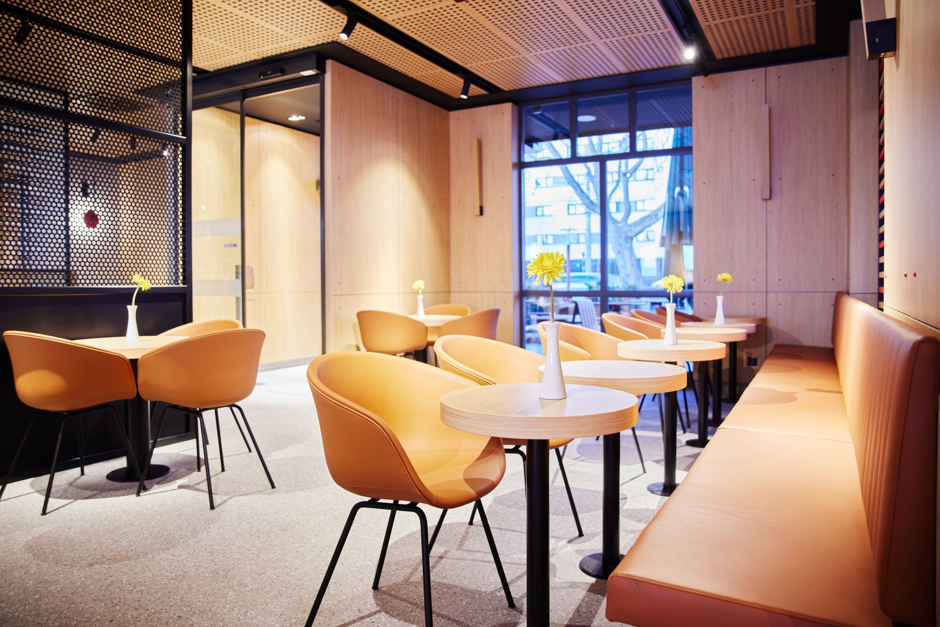 McDonald's Ray Graz - Professioneller Innenausbau, moderne Innenarchitektur mit orangefarbenen Sitzmöbeln, Holzelementen und optimiertem Beleuchtungskonzept - Referenzprojekt Generalunternehmer Innenausbau