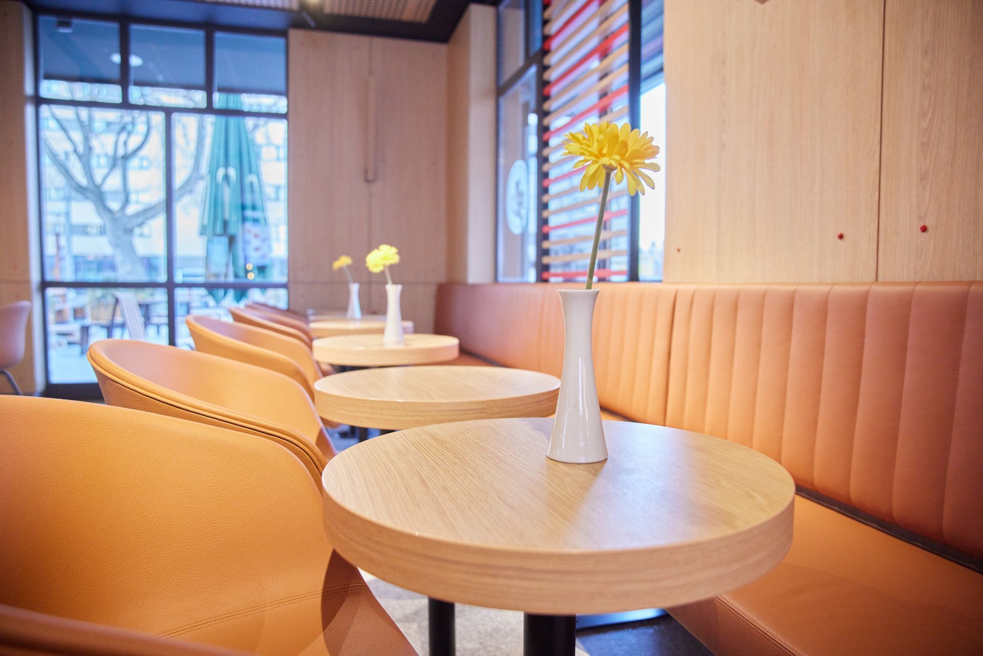 McDonald's Ray Graz - Professioneller Innenausbau, moderne Holzmöbel mit beigen Sitzbänken aus Lederoptik, Holzelementen - Referenzprojekt Generalunternehmer Innenausbau