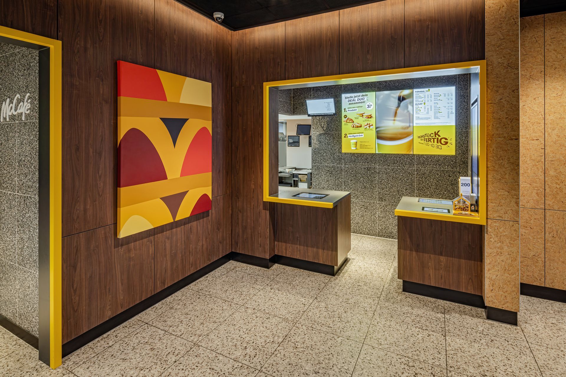 McDonald's A Touch of Archery Unterhaching - Restaurantumbau Möblierung und Einrichtung, Counter mit dekorativen Wand- und Leuchtelementen - Referenzprojekt Generalunternehmer Innenausbau