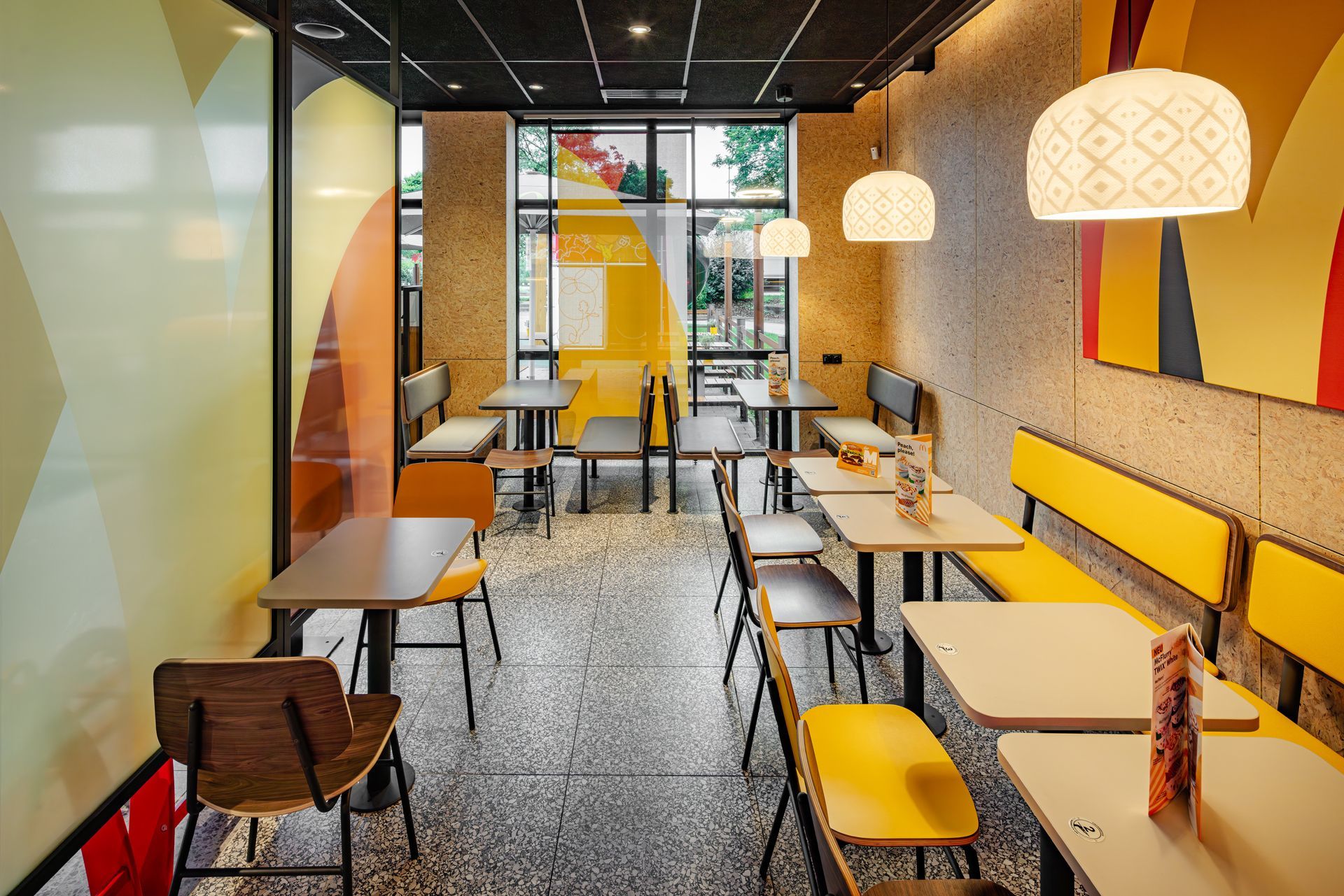 McDonald's A Touch of Archery Unterhaching - Restaurantumbau Möblierung, Sitzecke mit dekorativen Wand- und Leuchtelementen - Referenzprojekt Generalunternehmer Innenausbau