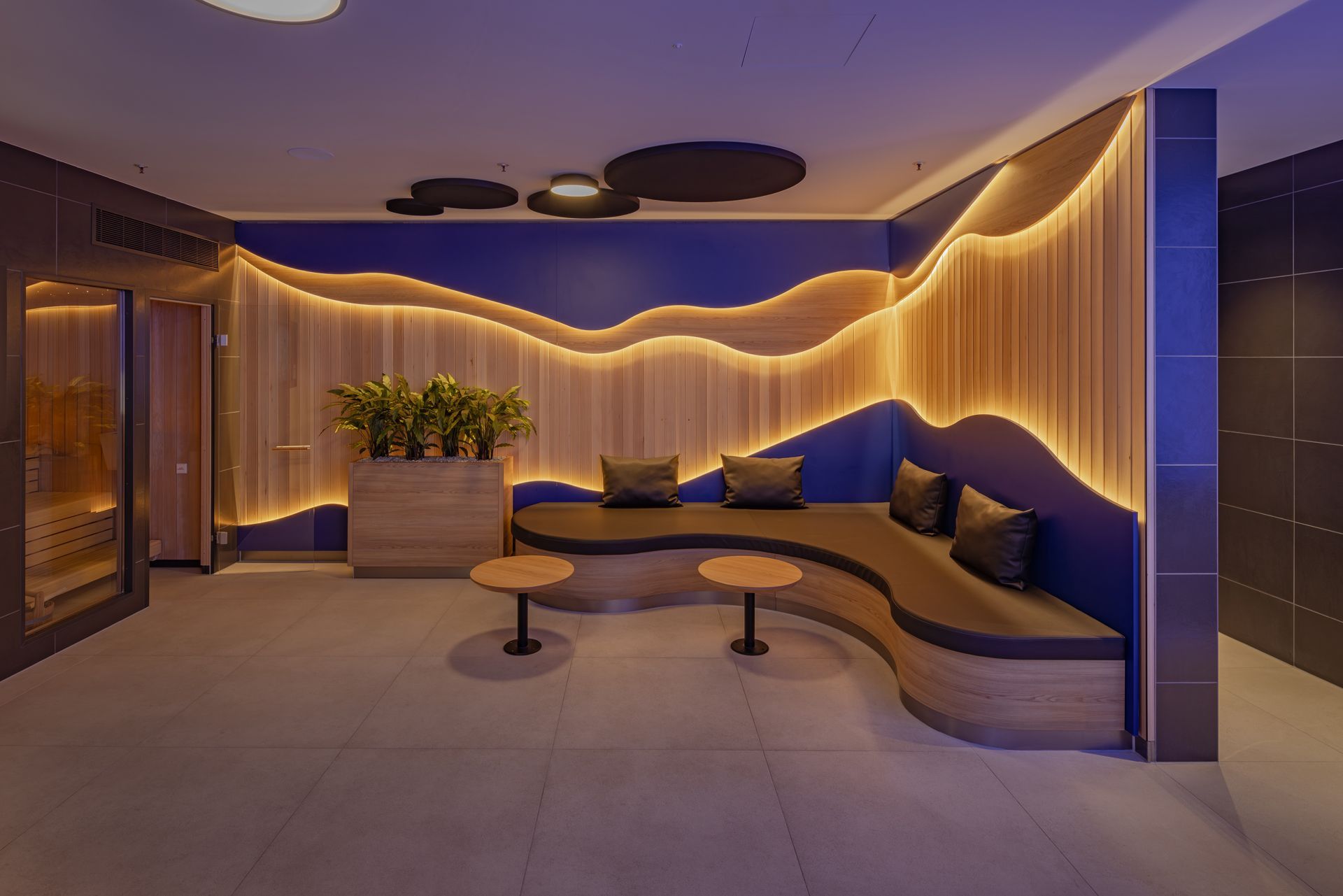Wellness und Spa Einrichtung MySpa Mannheim Innenausbau - Moderne Wellnesseinrichtung mit gemütlichem Sitzbereich, Holzwanddekor, warmer Beleuchtung - Referenzprojekt im Bereich Spa und Wellness Generalunternehmer