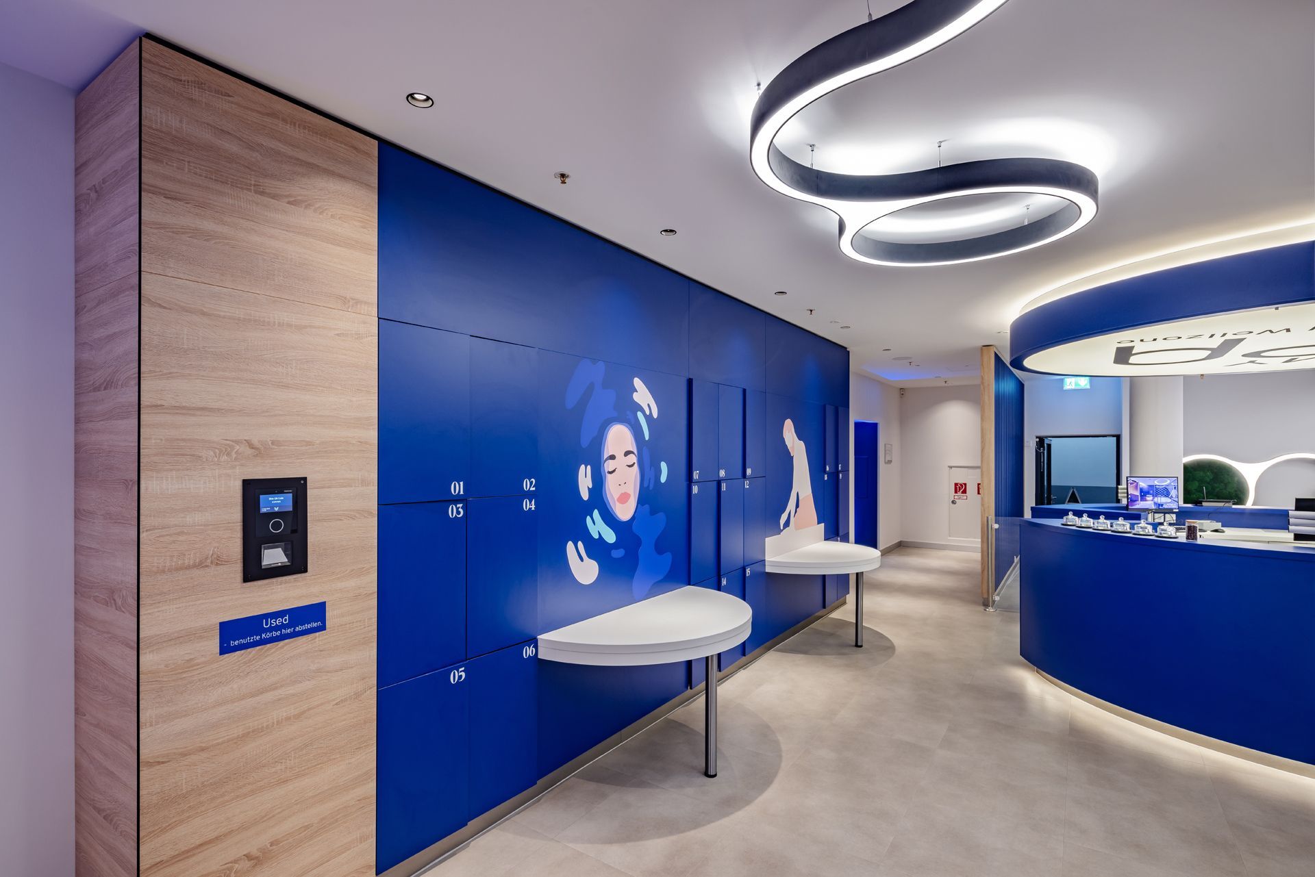 Wellness und Spa Einrichtung MySpa Mannheim Innenausbau - Moderner Empfangsbereich mit blauen Schließfächern und Aufbewahrungssystem, weißen Deckenleuchten - Referenzprojekt im Bereich Spa und Wellness Generalunternehmer