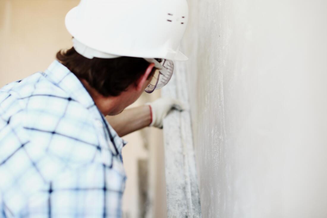 man installing stucco on a home