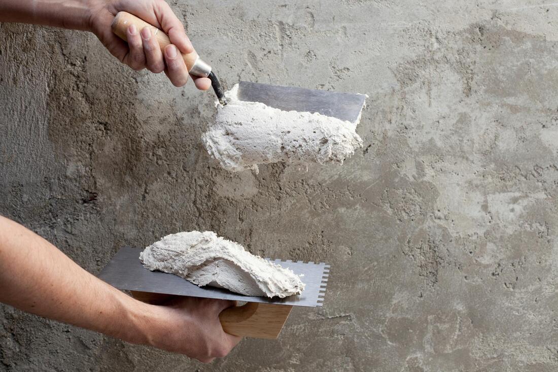 man repairing a stucco wall in mesa az
