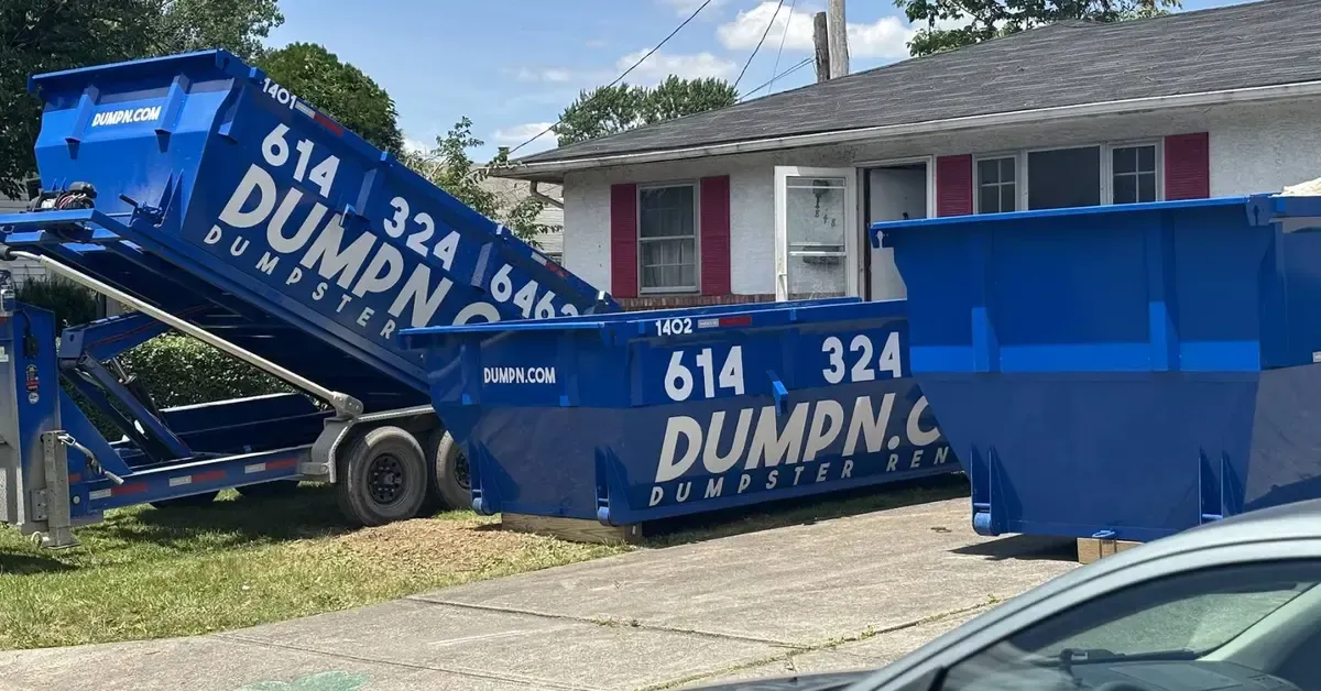 15-yard and 20-yard dumpster rental size comparison in a driveway