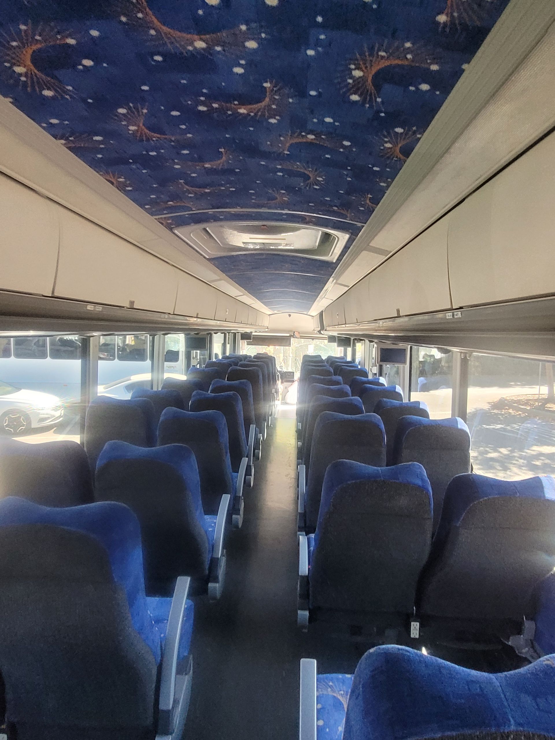 The inside of a bus with blue seats and a blue ceiling