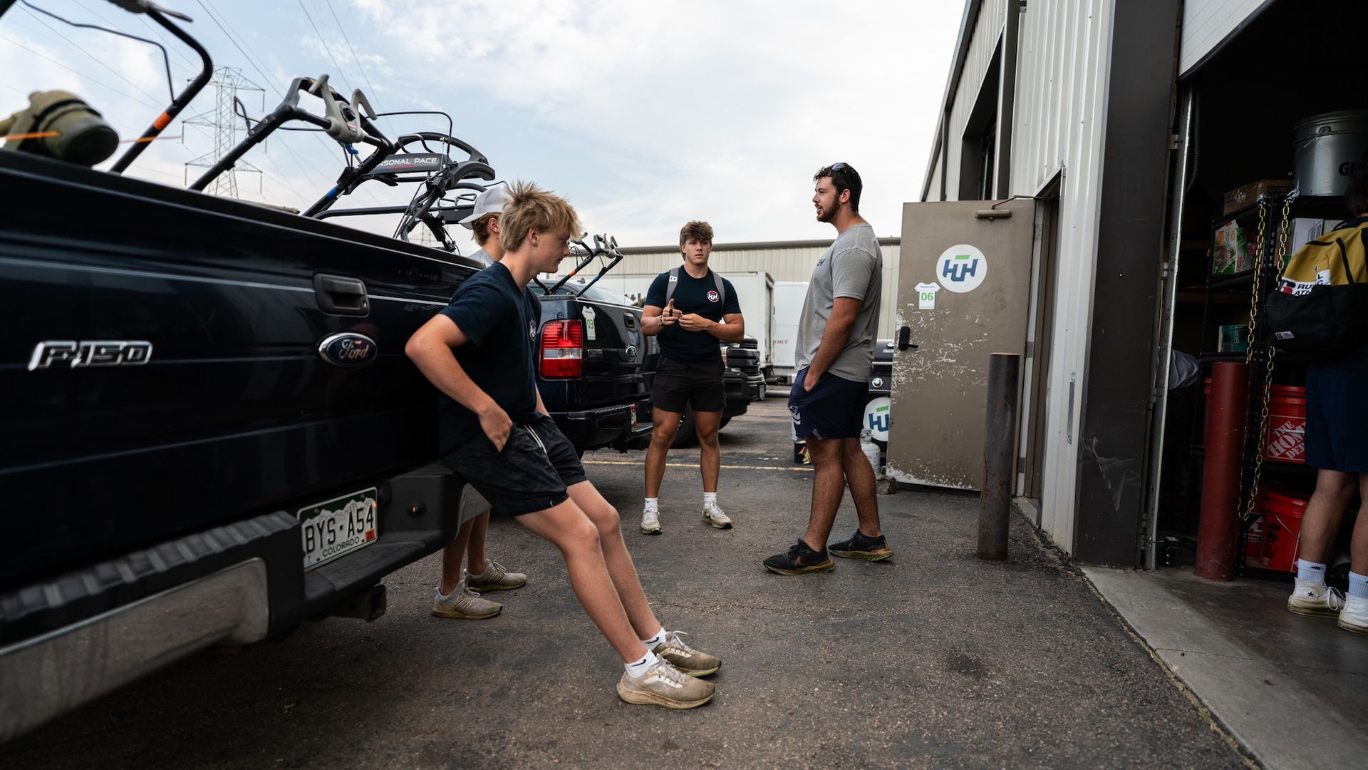 A group of people are doing push ups in front of a truck.