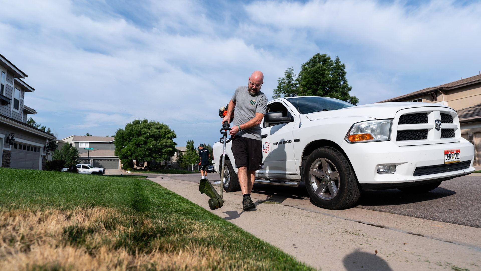 A man is standing next to a white truck on the side of the road.