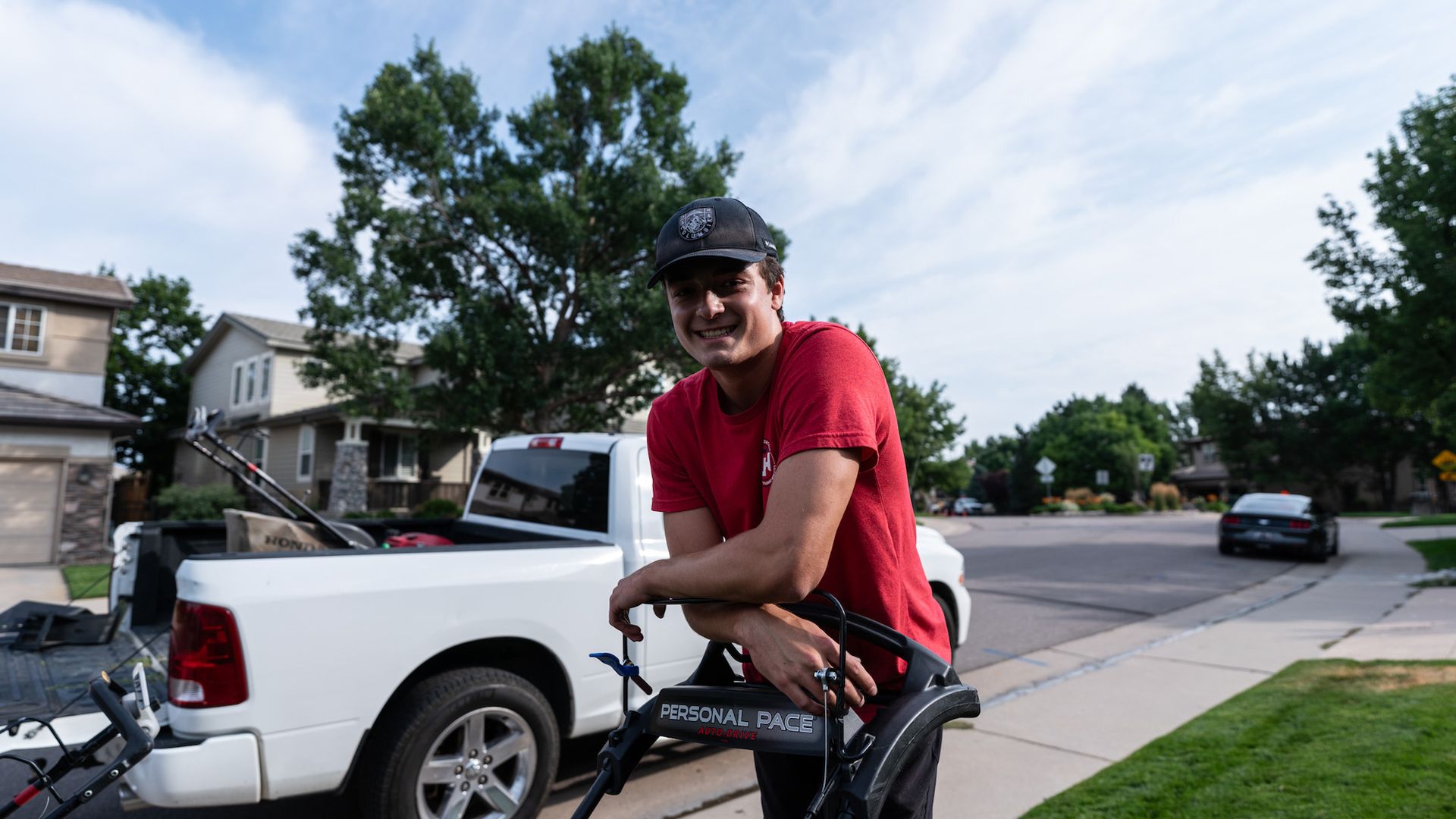A man is leaning on a bicycle in front of a white truck.