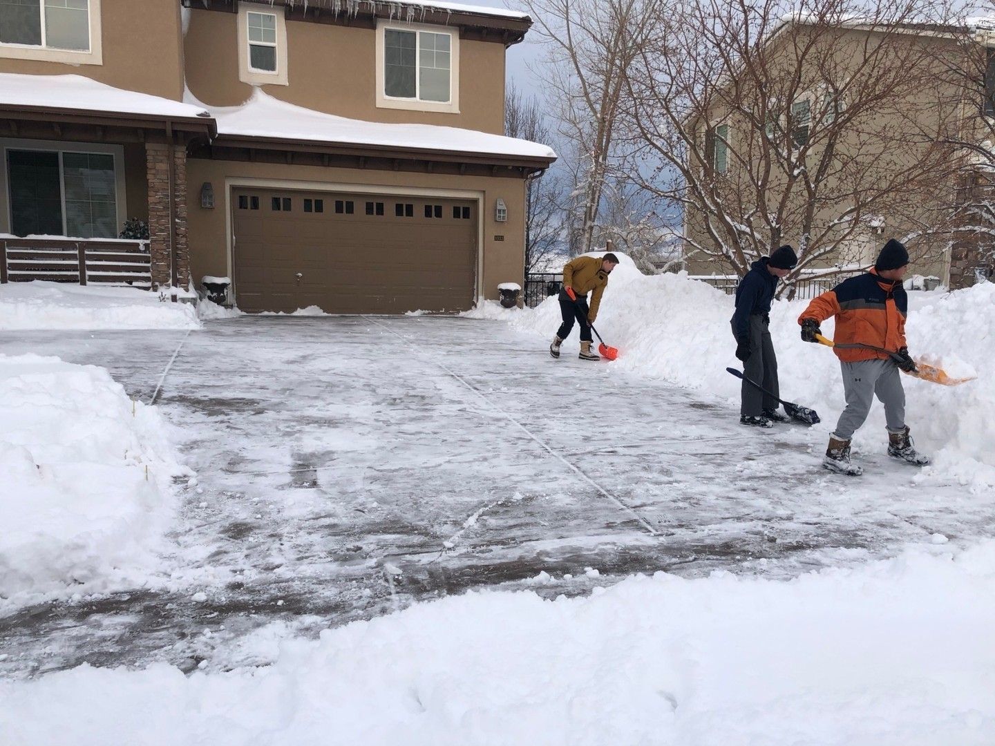 People removing snow on the driveway.