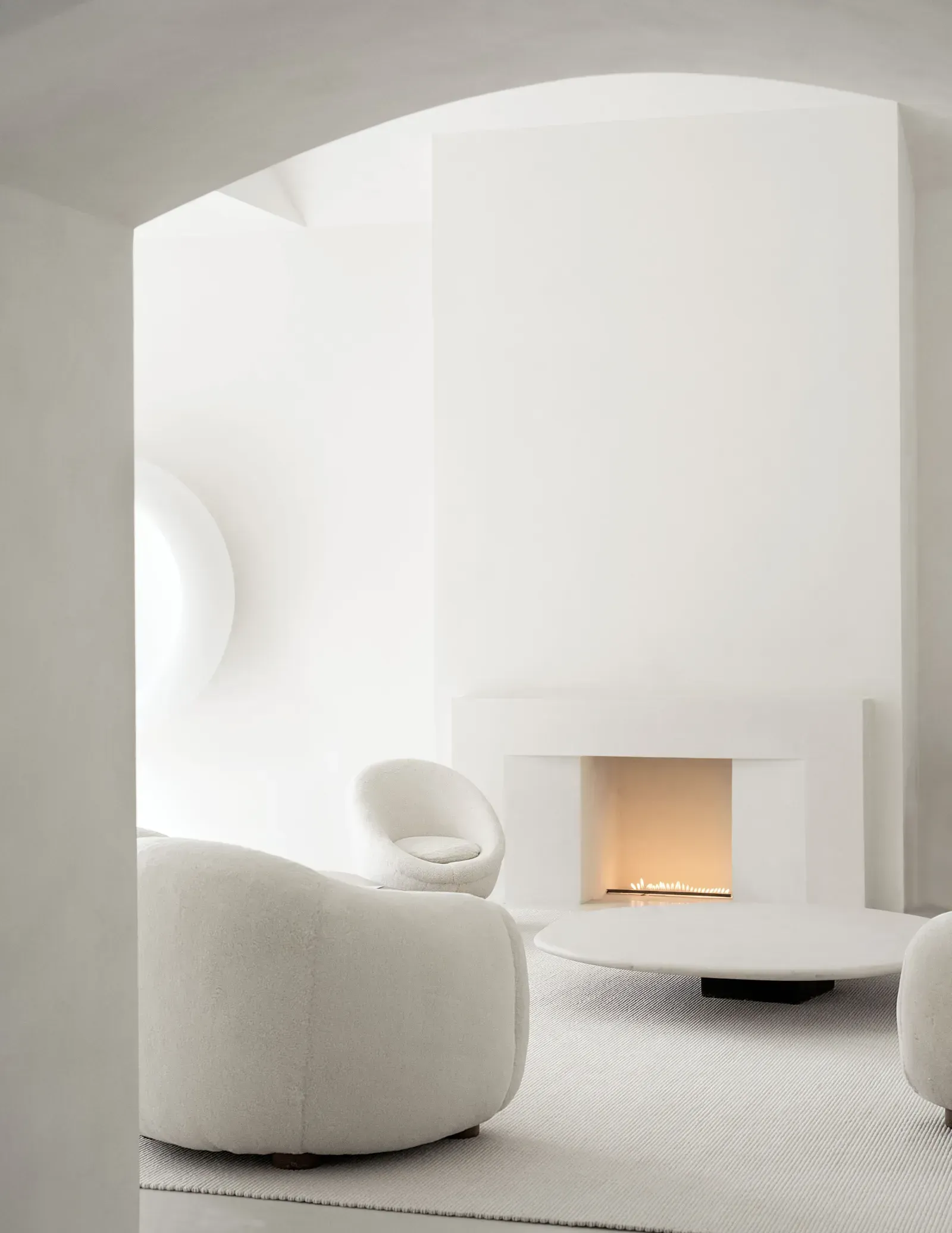 Un living cu mobilier alb si un semineu