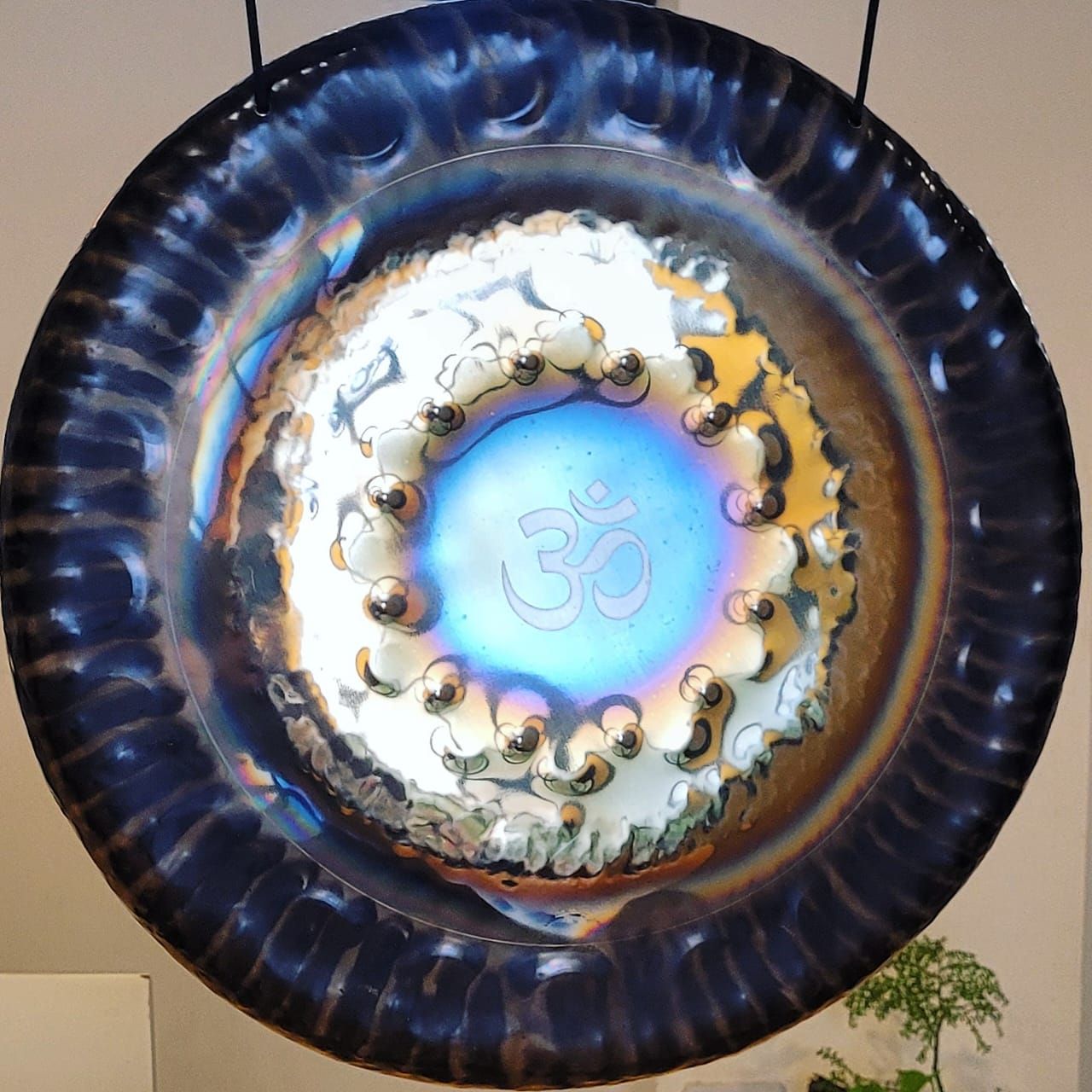 Gong con tonos azules y dorados, grabado con el símbolo Om.
