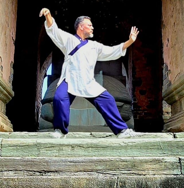 Profesor Cristian Medina haciendo una pose de Tai chi en la entrada de un templo en China.