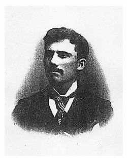 Black-and-white portrait of a man in a suit and tie, facing slightly left with a serious expression