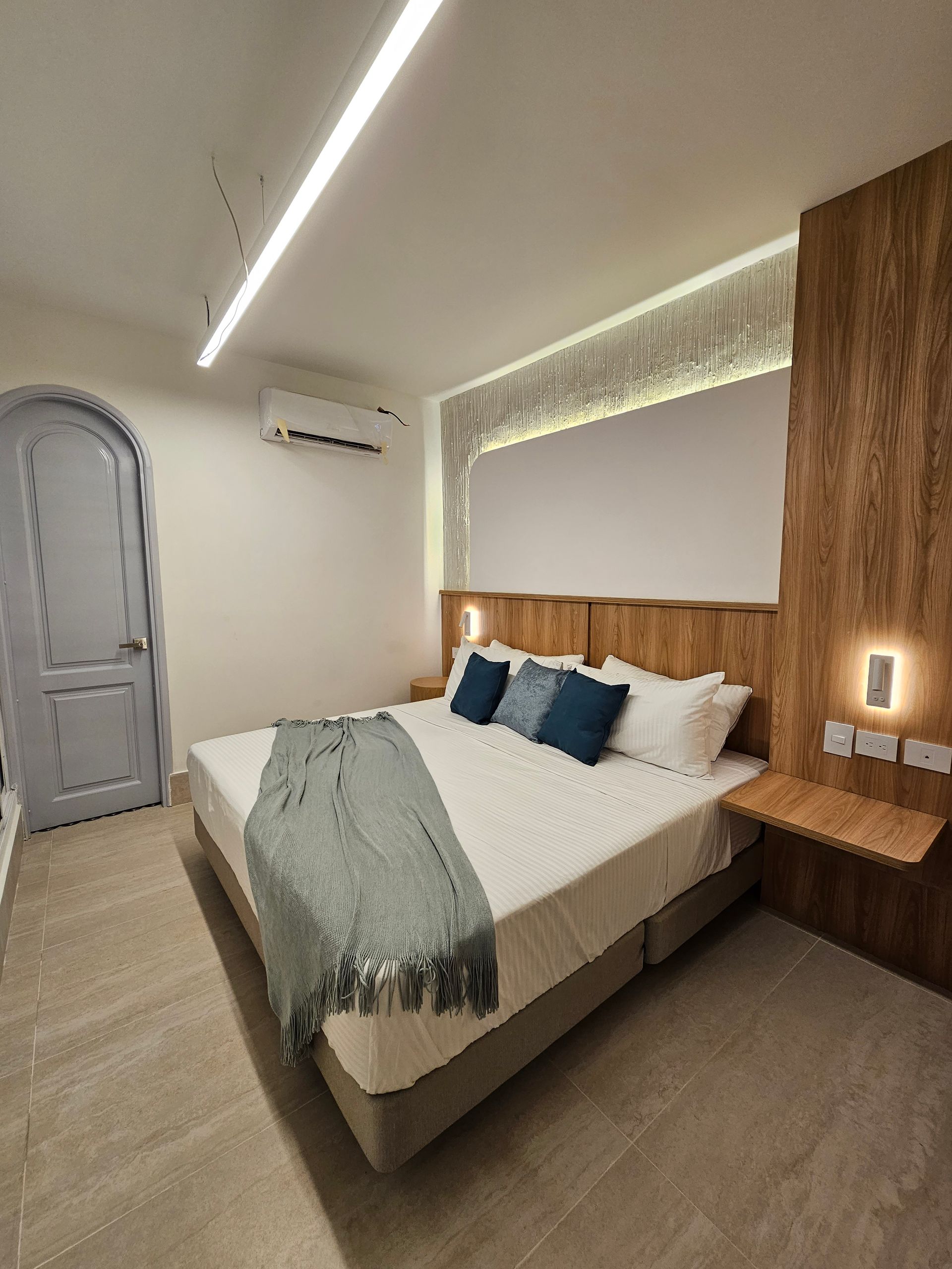 Una habitación de hotel con una cama tamaño king y almohadas azules.