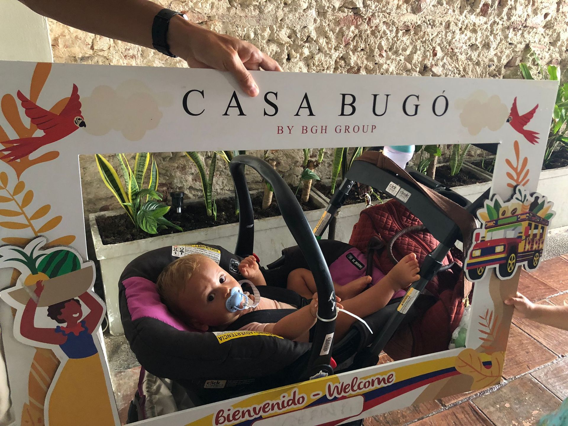 Baby in a car seat inside a photo frame that says 