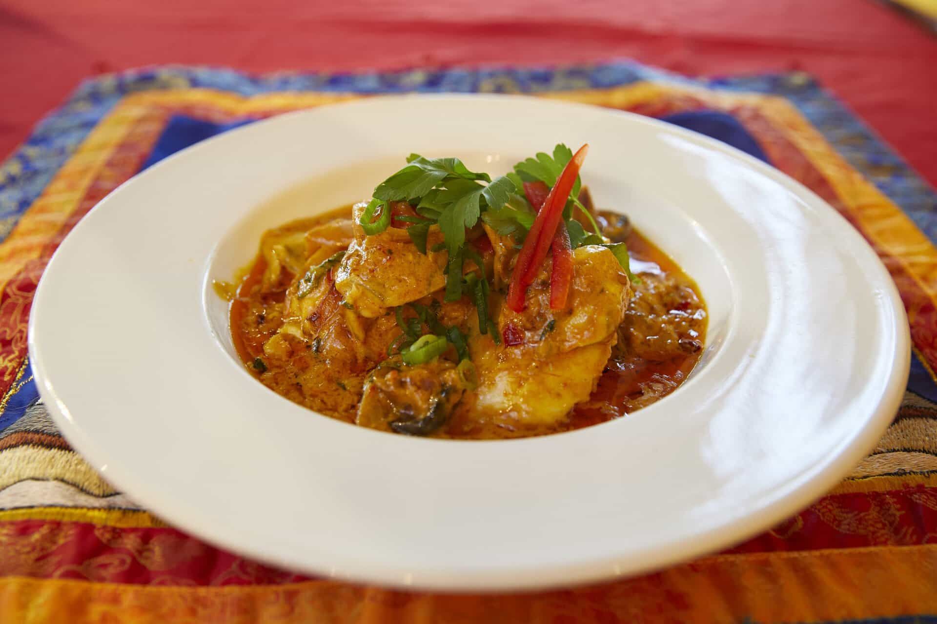 White Plate Topped With a Curry Dish on a Table — Kathmandu Kitchen in Kingscliff, NSW