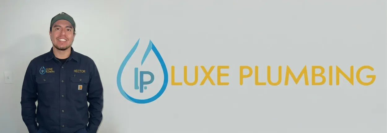 Man standing beside the Luxe Plumbing logo on a light gray background