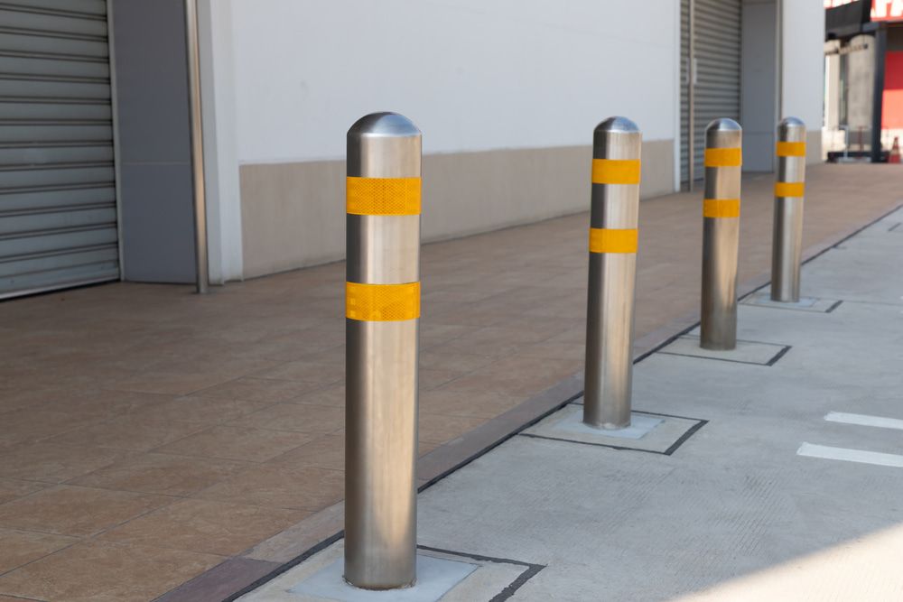 A row of stainless steel poles with yellow stripes on them — On The Spot Steel Fabrication in Caloundra West, QLD