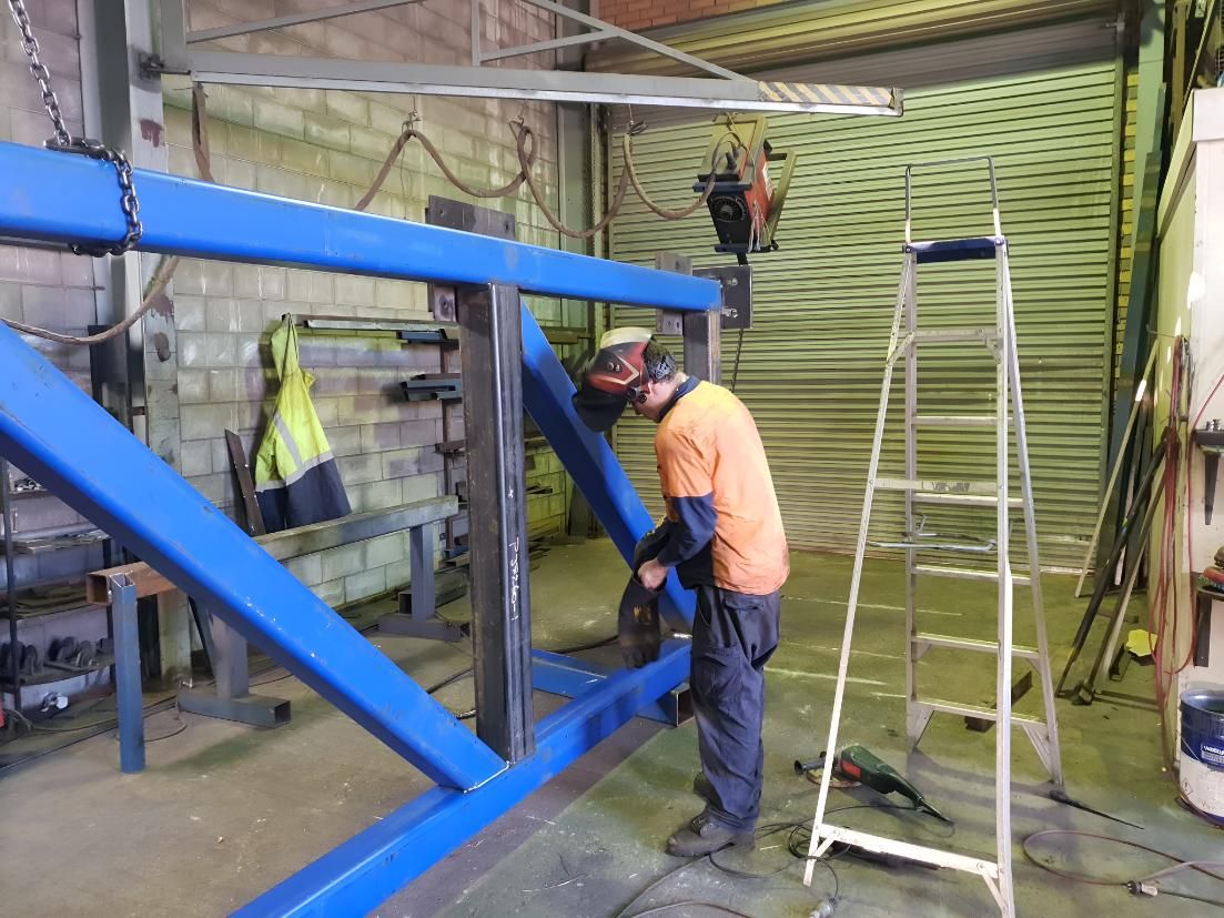 Man is Welding a Blue Metal Structure — On The Spot Steel Fabrication in Caloundra West, QLD