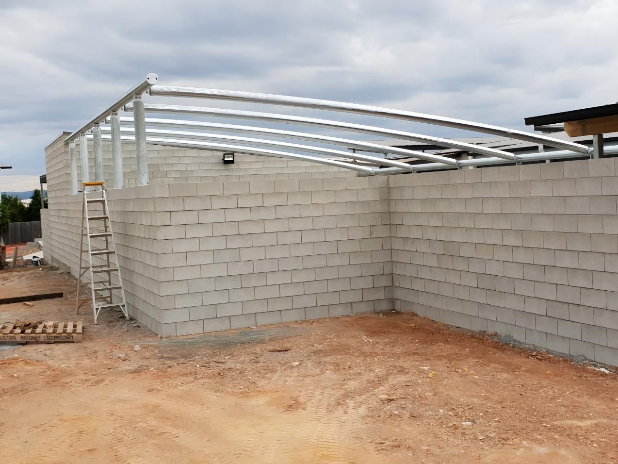 Metal Structure is Being Built on Top of a Brick Wall — On The Spot Steel Fabrication in Caloundra West, QLD