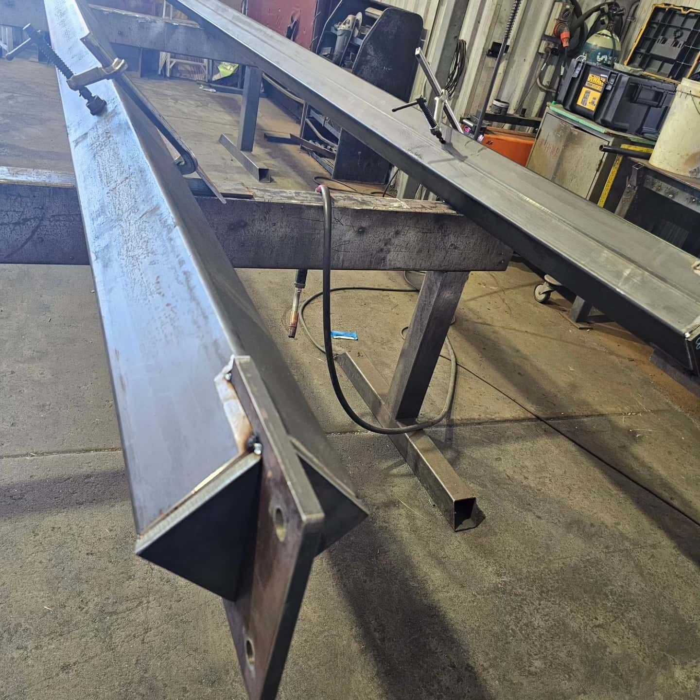 A large piece of metal is sitting on top of a wooden table. — On The Spot Steel Fabrication in Caloundra West, QLD