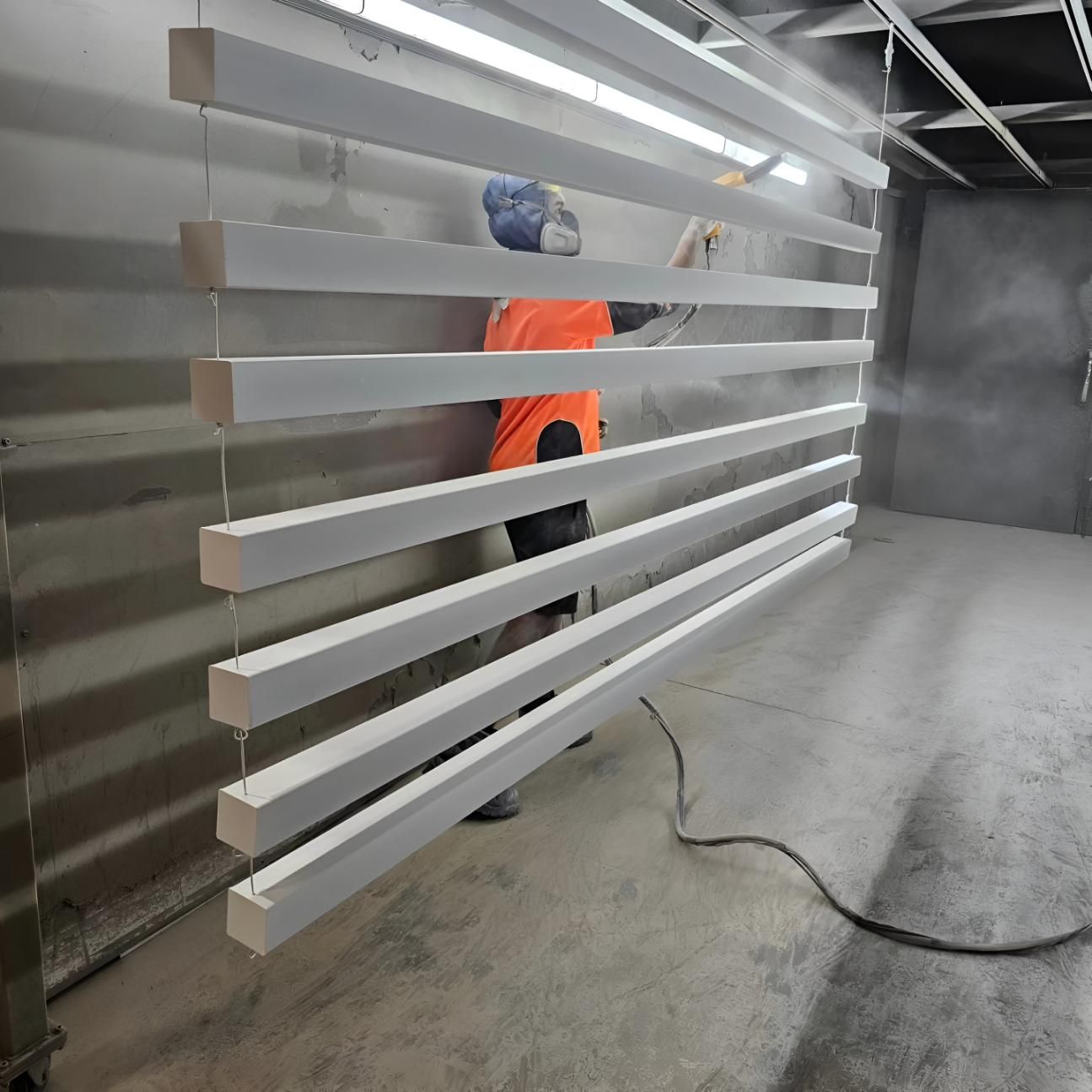 Man is Painting a Row of White Bars in a Room — On The Spot Steel Fabrication in Caloundra West, QLD