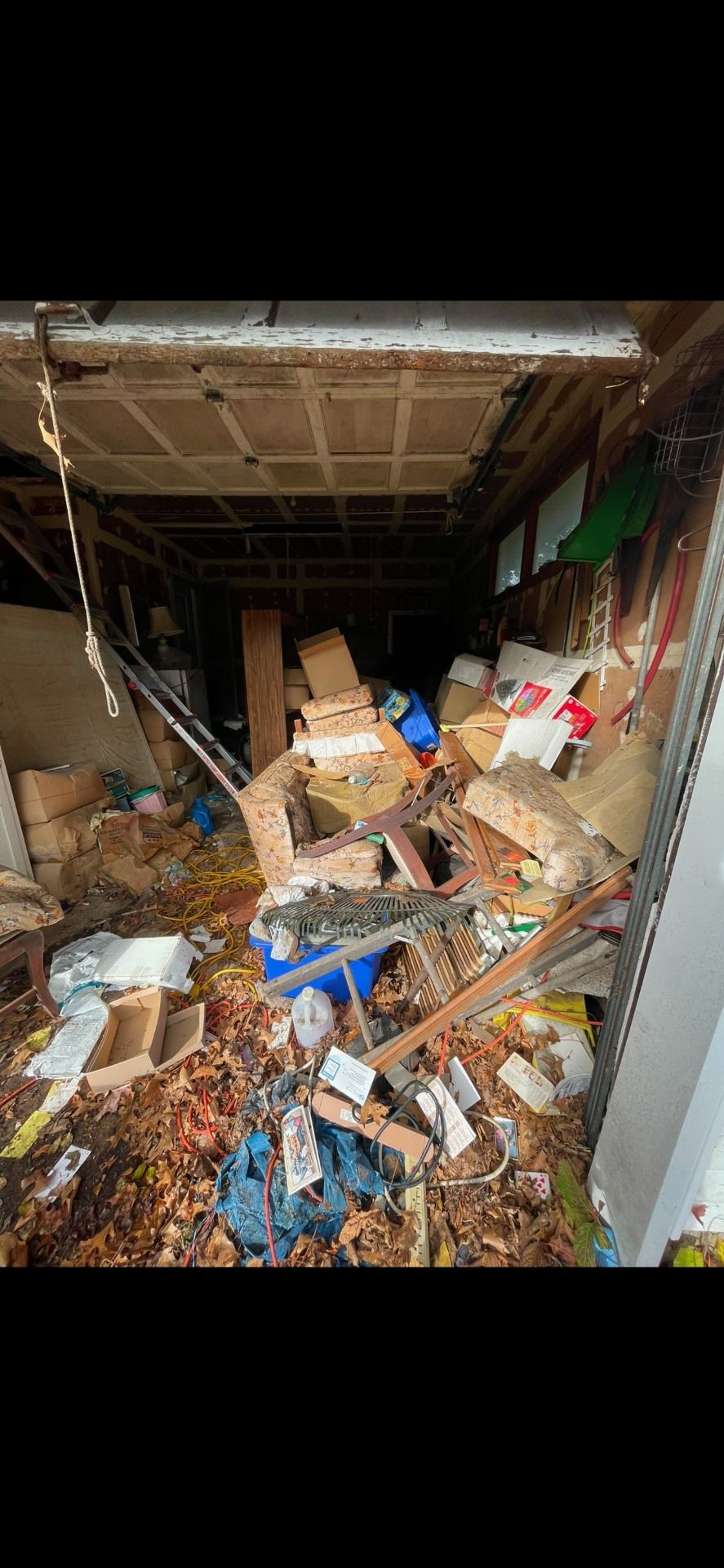 An extremely cluttered and disorganized storage space. Boxes, debris, and materials fill the area.