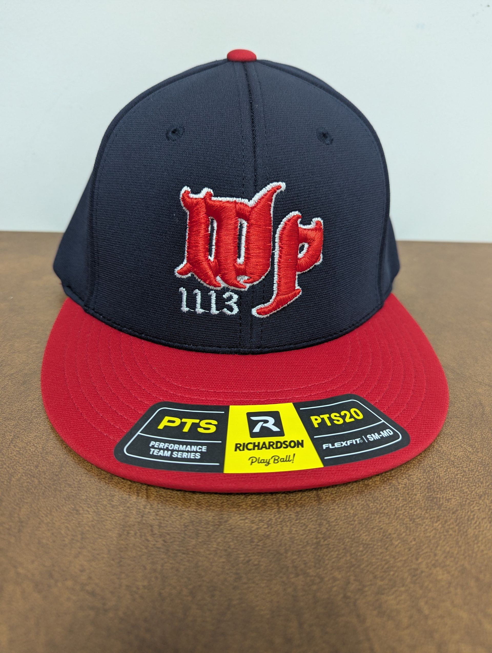 Black and red baseball cap with red embroidered logo and patches on the brim