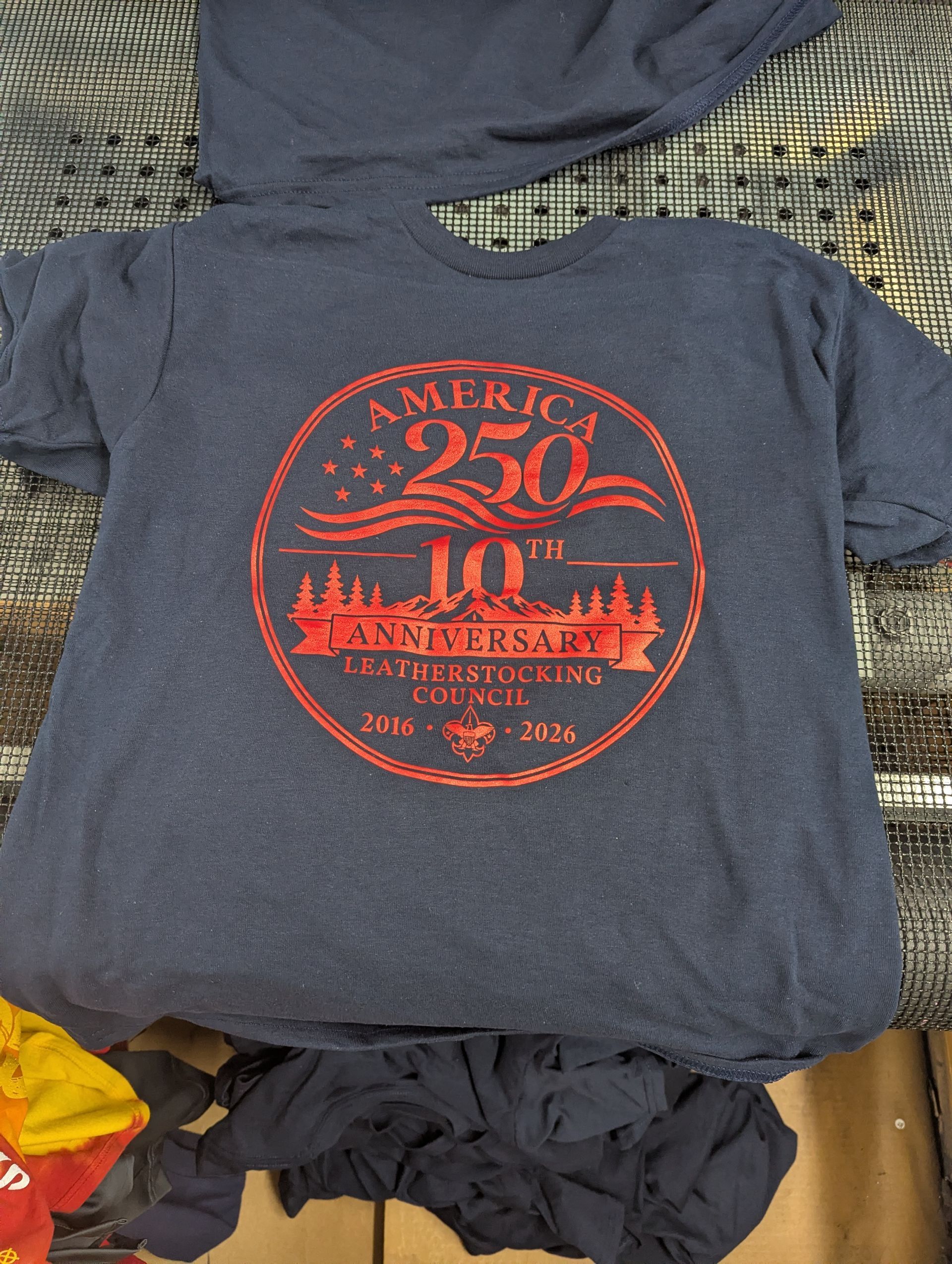 Dark gray T-shirt with a red circular “America 250” patriotic print on the front