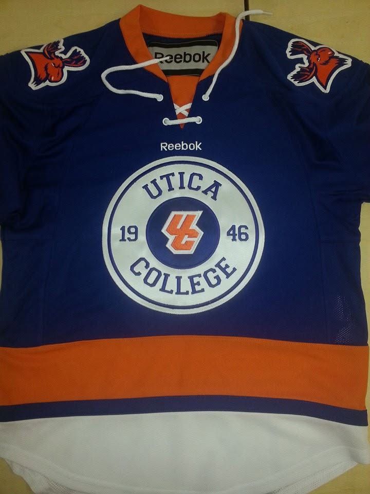 Blue Utica College hockey jersey with orange trim and white crest logo centered on the front.