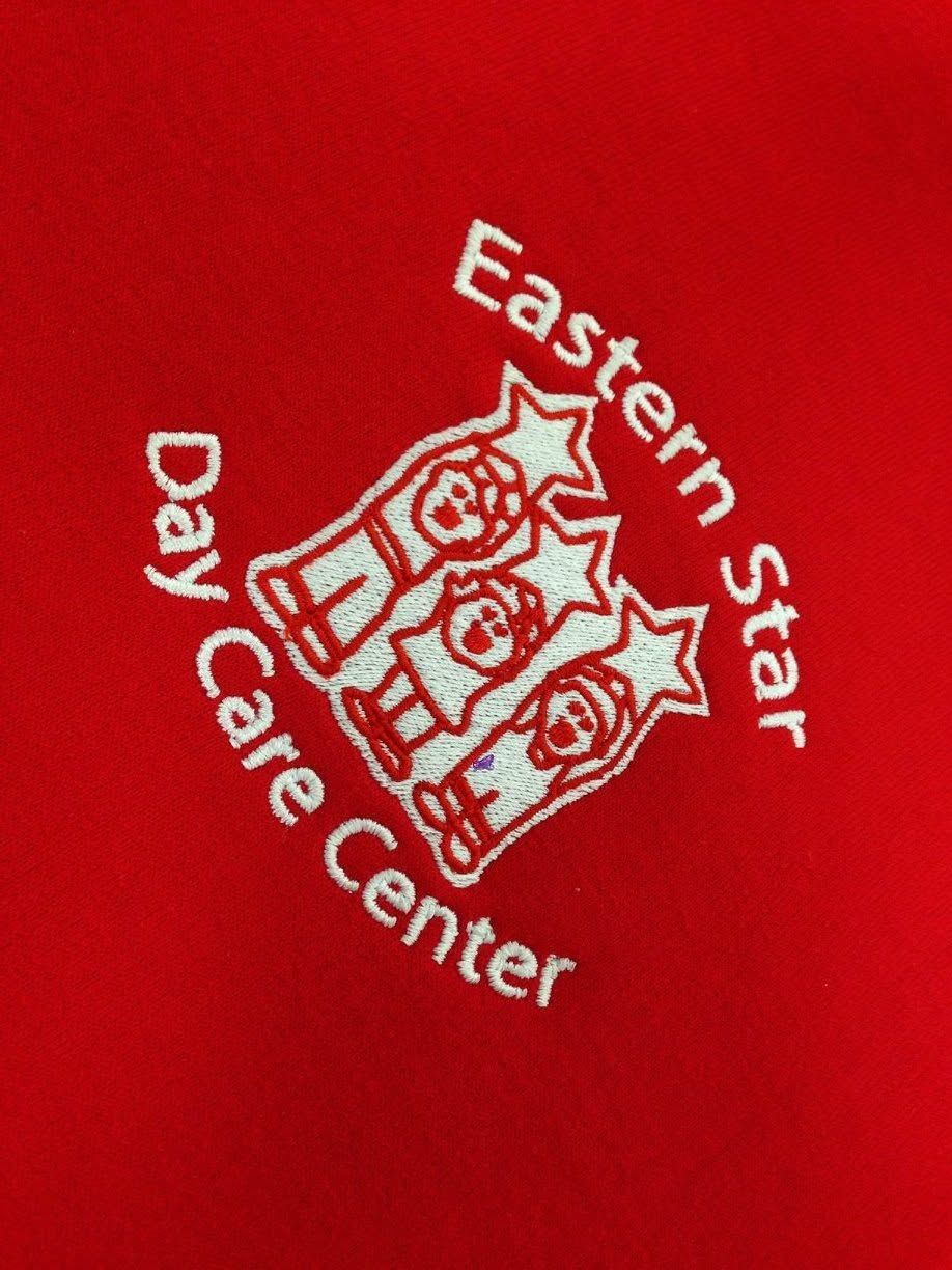 Red shirt with white “Eastern Star Day Care Center” logo and emblem.