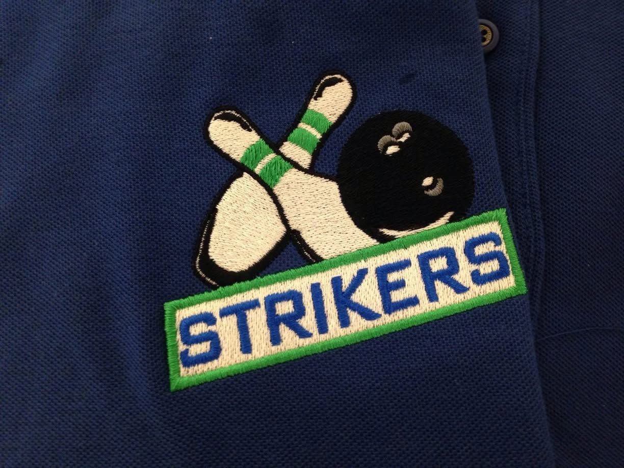 Blue jacket with a bowling pins-and-ball “STRIKERS” patch in green, white, and blue.