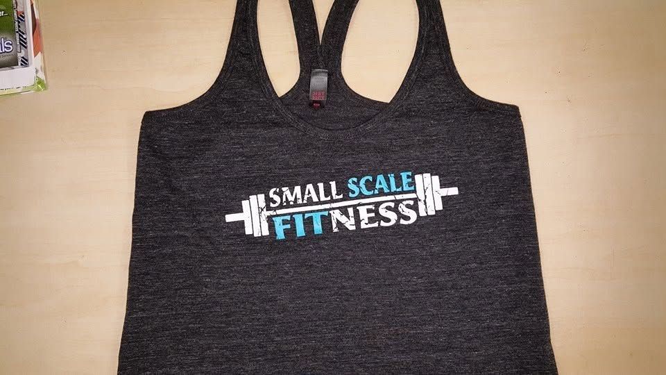 Dark gray racerback tank top with “Small Scale Fitness” logo printed on the front.