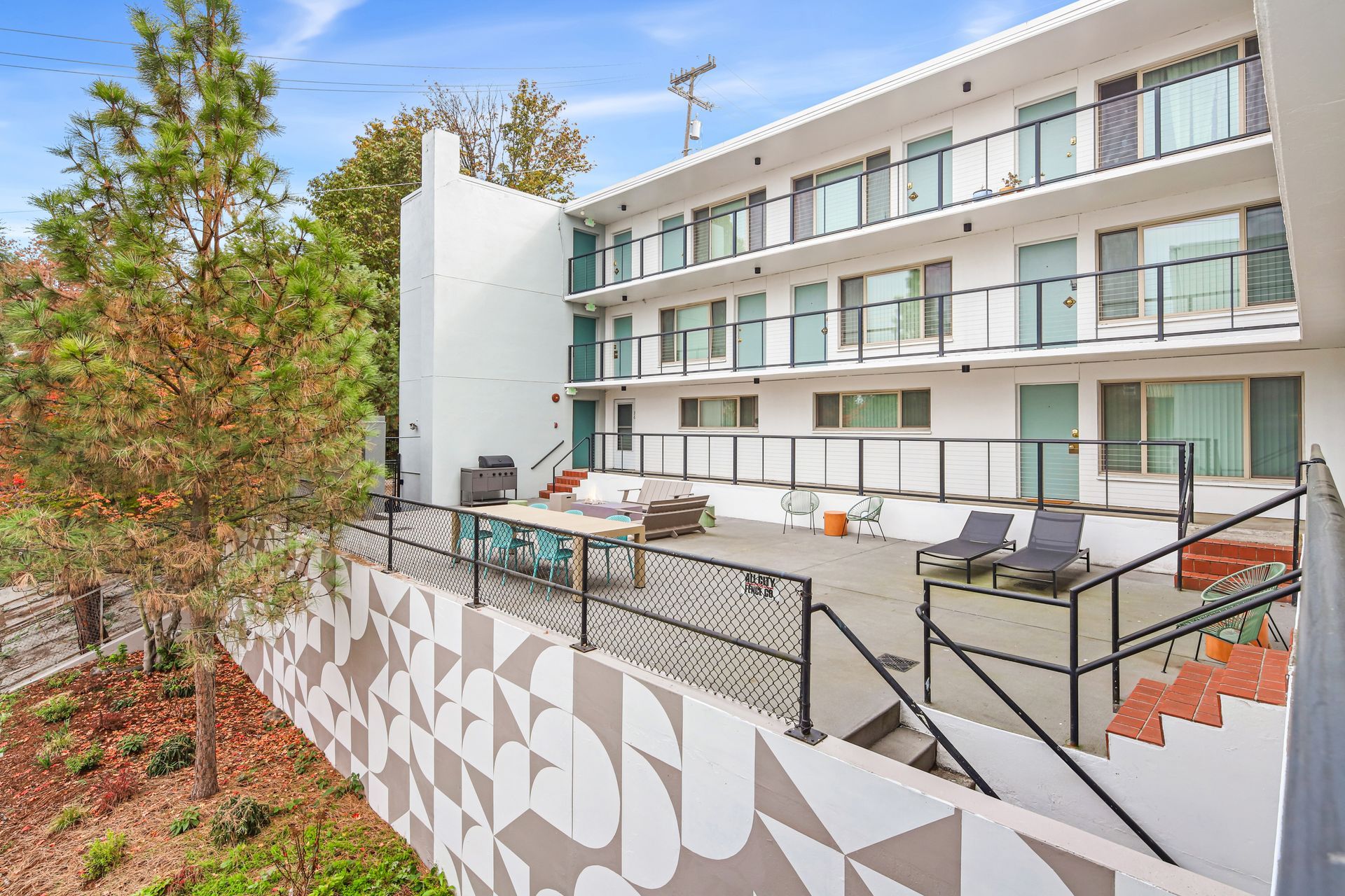 A large white building with a balcony and stairs leading up to it.