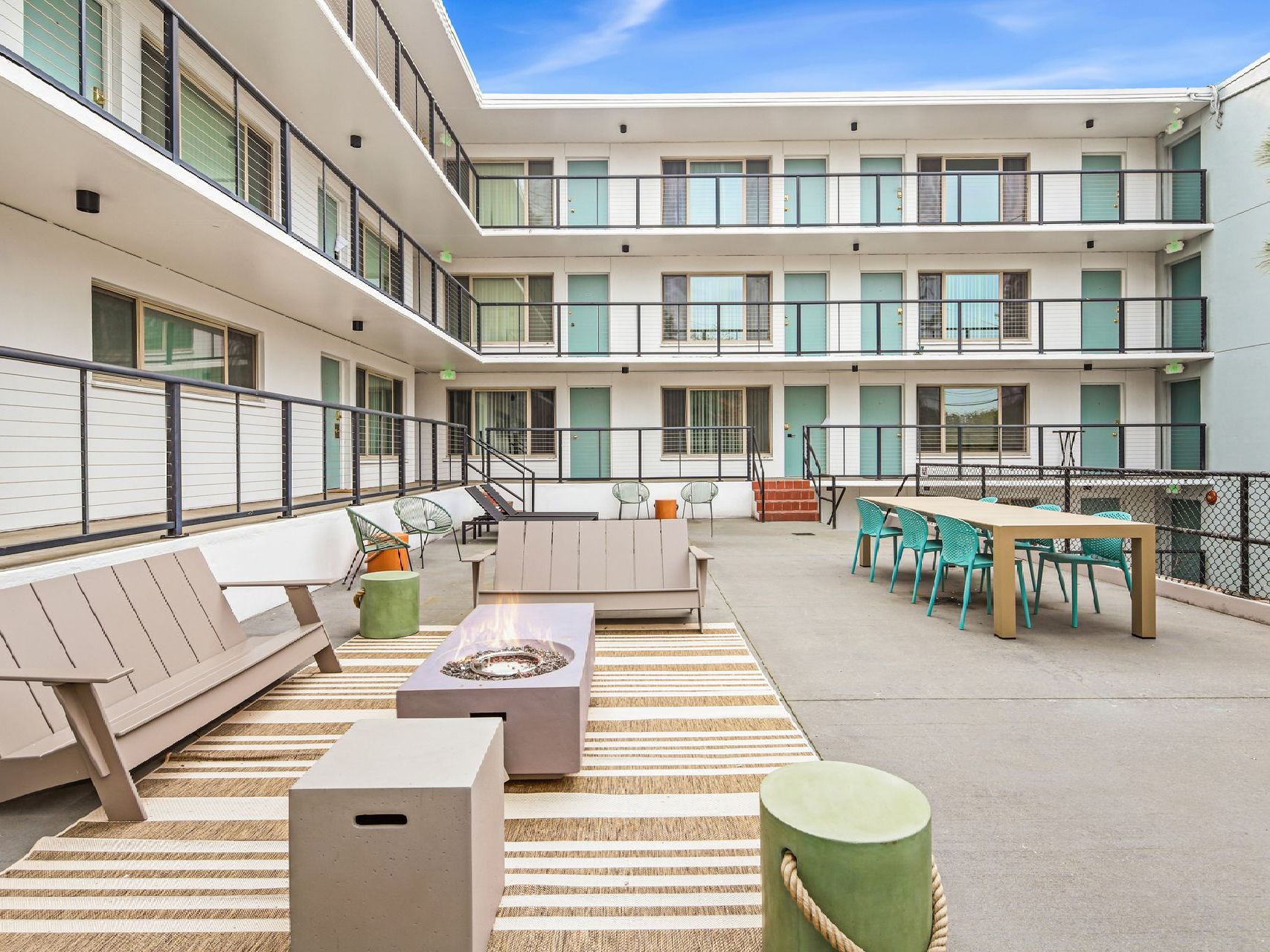 A large apartment building with a patio area with furniture and a table.