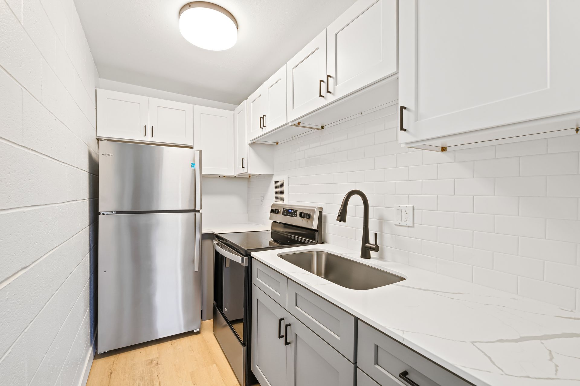 A kitchen with stainless steel appliances and white cabinets.