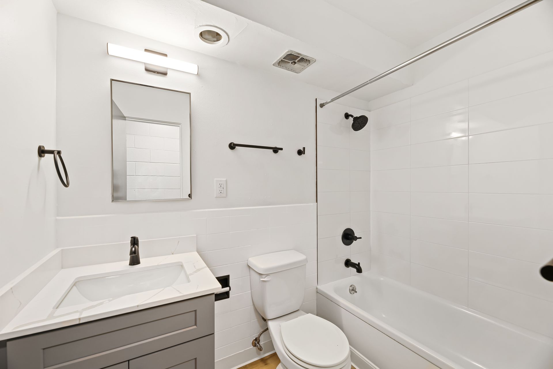 A bathroom with a toilet , sink , and bathtub.