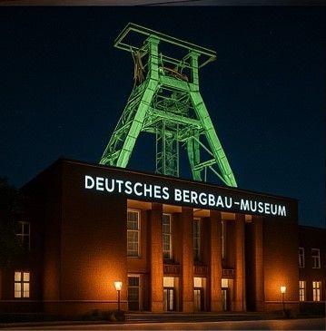 Das nachts beleuchtete Gebäude des Deutschen Bergbau-Museums mit grünem Förderturm.