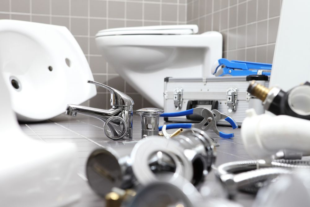 Bathroom Remodel Scene With a Toilet, Sink, Faucet, and Plumbing Tools — Pure Plumbing & Electrical in Dubbo, NSW