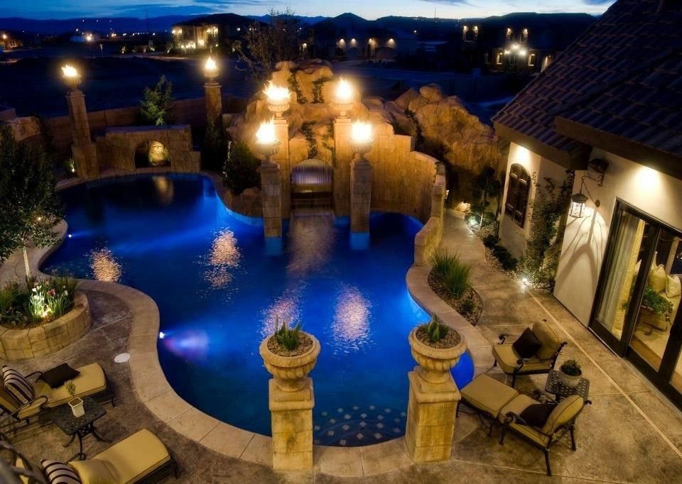 A large swimming pool is lit up at night