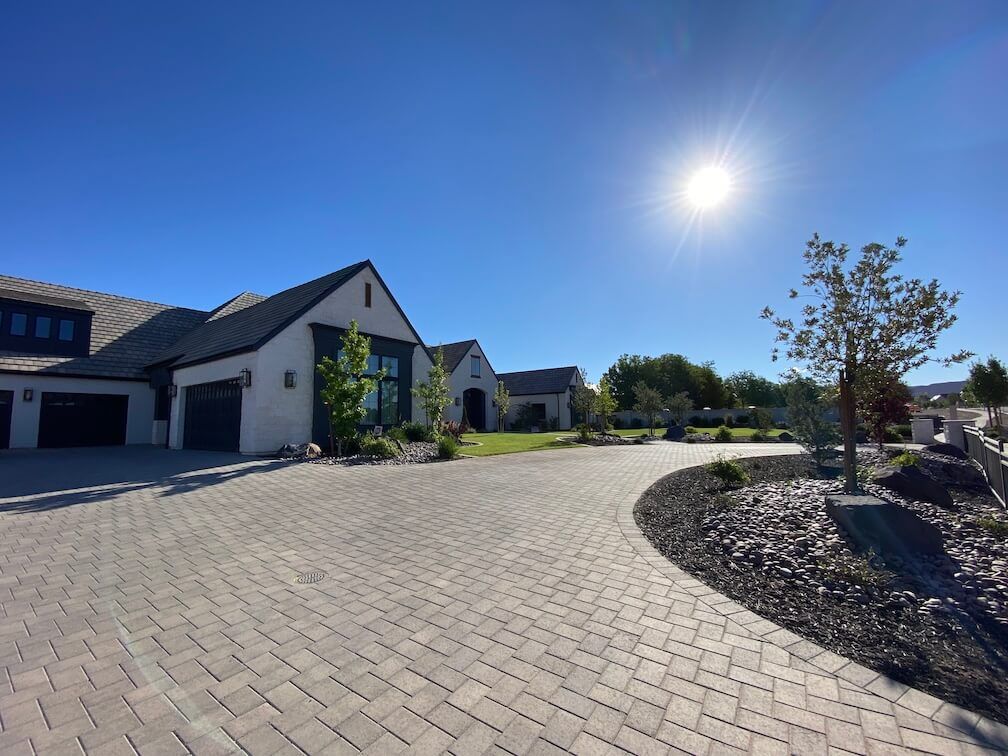 A large house with a brick driveway in front of it.