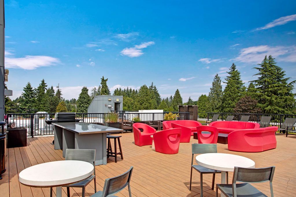 There are many red chairs and tables on the patio.